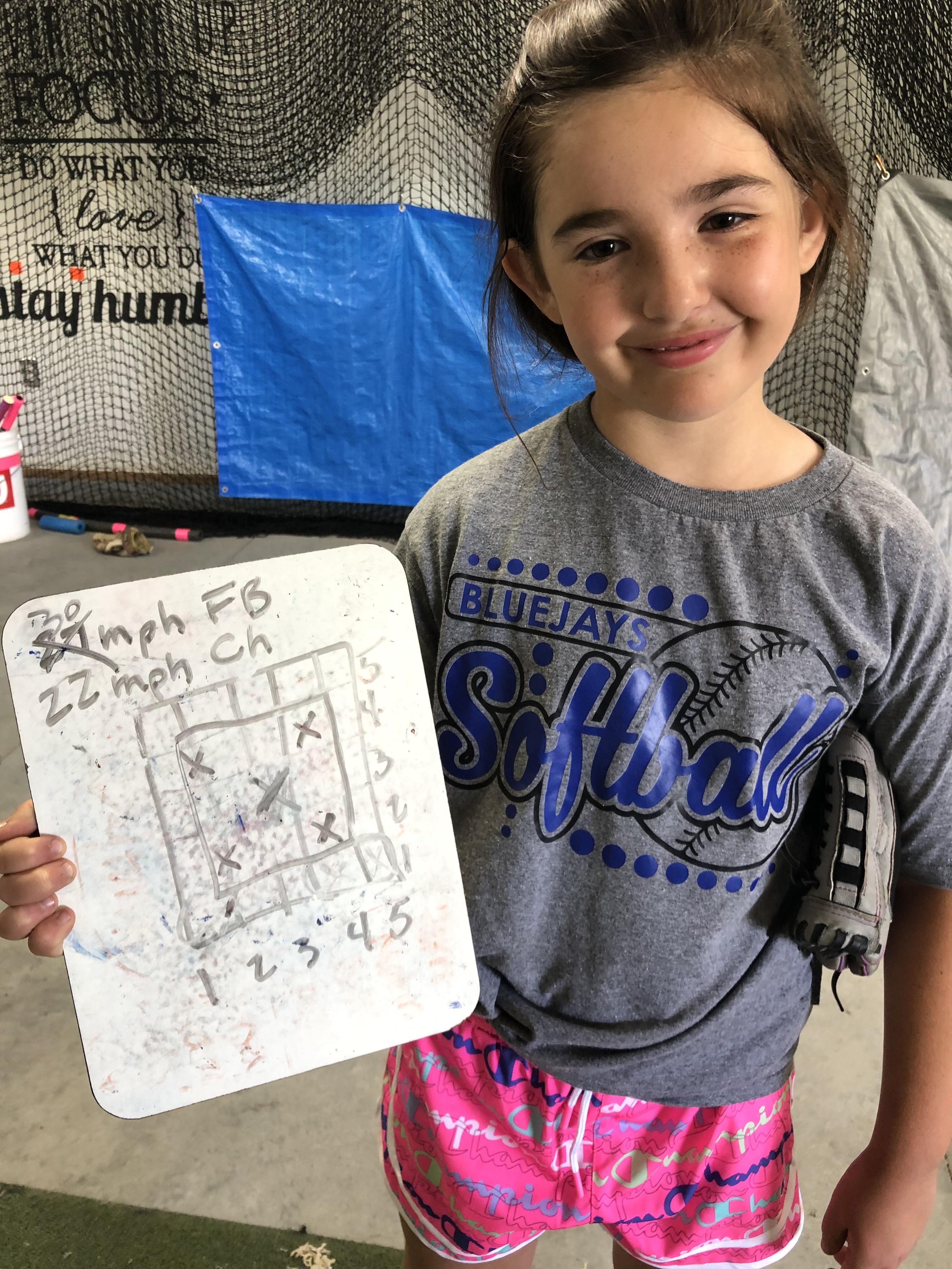 Player holding a pitch chart while smiling for the camera