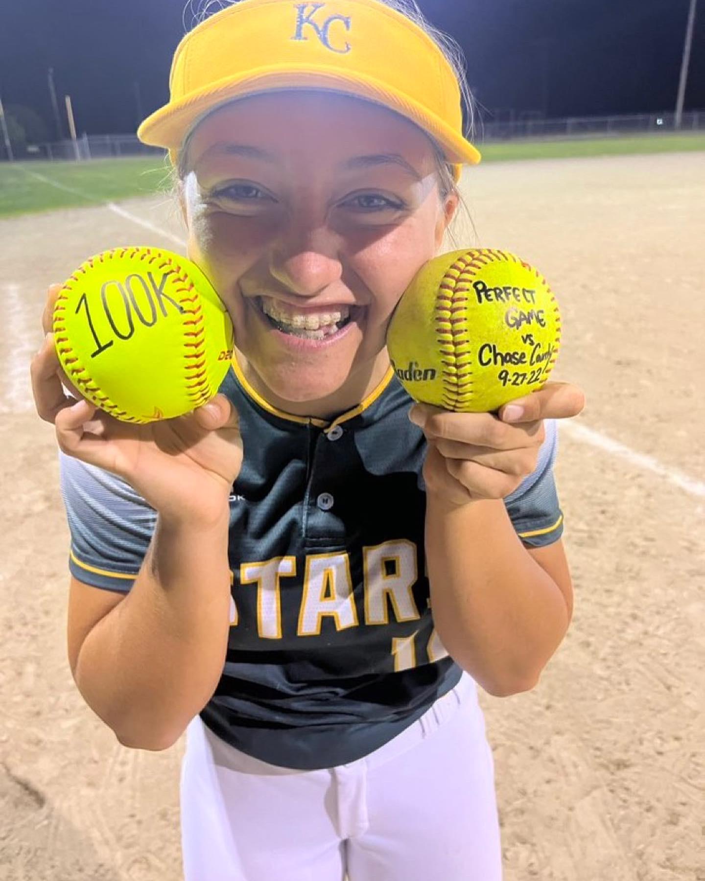 Player smiling while holding a 100K ball and a perfect game ball