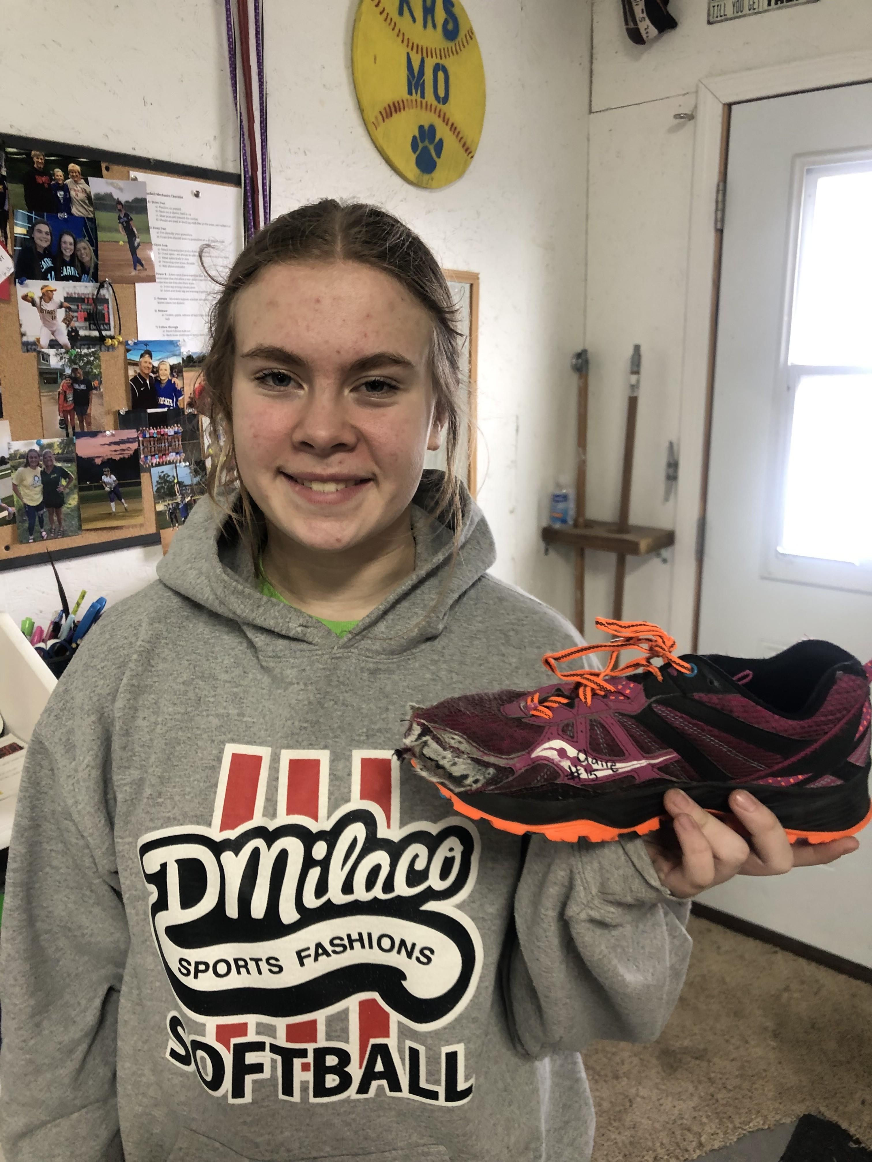 Player smiling while holding a signed cleat