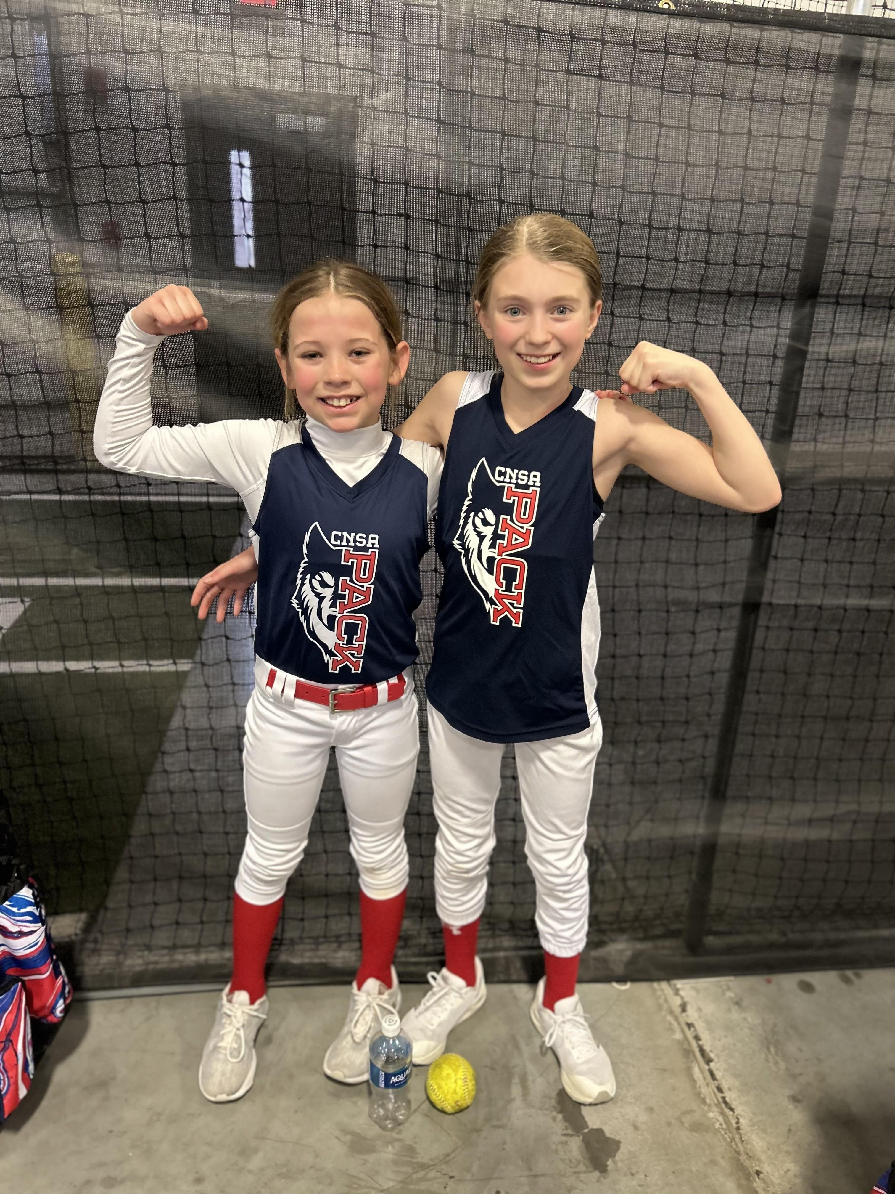 Two CNSA Pack teammates flexing and smiling in their jerseys