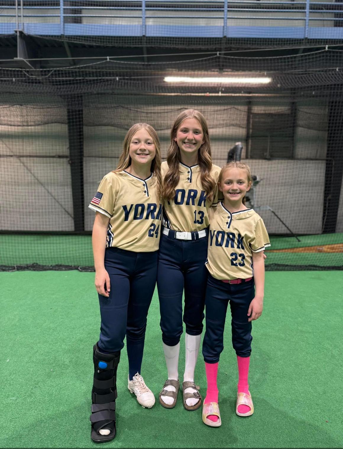 Three York softball teammates smiling together indoors